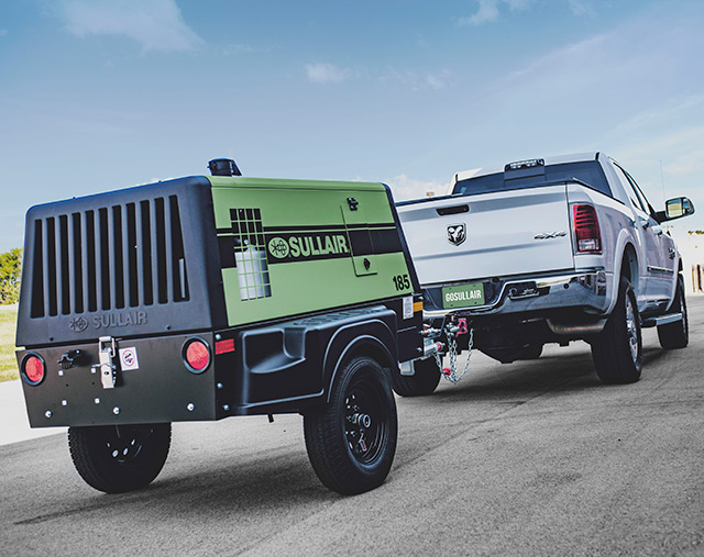 Sullair 185 portable deisel air compressor being towed by a pickup